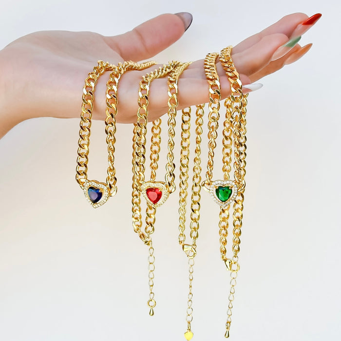 Dainty gold layered necklace, wholesale jewelry for women's boutiques, statement accessory, boutique wholesale jewelry, waterproof necklaces, statement gold necklace, trendy gold jewelry, hypoallergenic jewelry, tarnish-free necklace, gold chunky chain necklaces with blue, red, and green heart-shaped gemstone pendants
