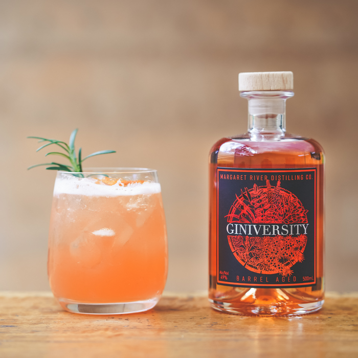 Giniversity Barrel Aged 500ml bottle next to a Lady Marmalade cocktail