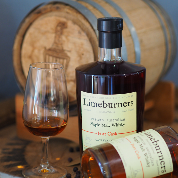 Limeburners Port Cask Strenght 61% 700ml bottle next to a glass with a pour of whisky. Mini Limeburners barrel in the background