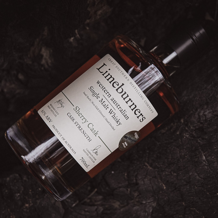 Limeburners Sherry Cask Strength 61% 700ml bottle laying down on a log