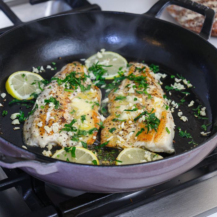 Rainbow trout cooking in a pan